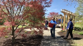 Volunteers via United Way's early session of the Day of Caring clean up the garden beds of the Remember Garden at Highland Park on Thursday.