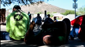 Men lay in the shade while waiting for potential employers at the Southside Worker Center in south Tucson on Friday, Oct. 20, 2023.