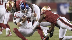 New York Giants quarterback Daniel Jones (8) is tackled by San Francisco 49ers defensive tackle Javon Kinlaw, top, and cornerback Deommodore Lenoir during the second half of an NFL football game in Santa Clara, Calif., Thursday, Sept. 21, 2023. (AP Photo/Godofredo A. Vásquez)