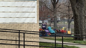A photo of a child care center with a playground in the background. 