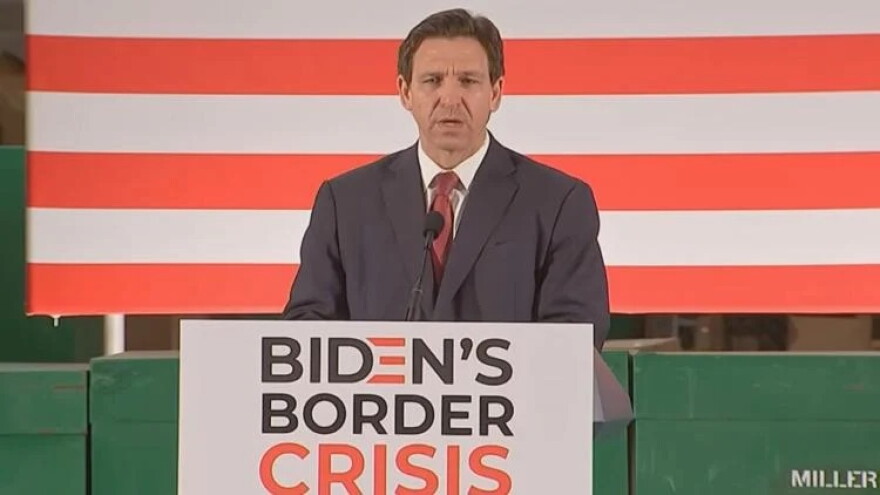 Gov. Ron DeSantis signs an immigration bill during an appearance in Jacksonville.