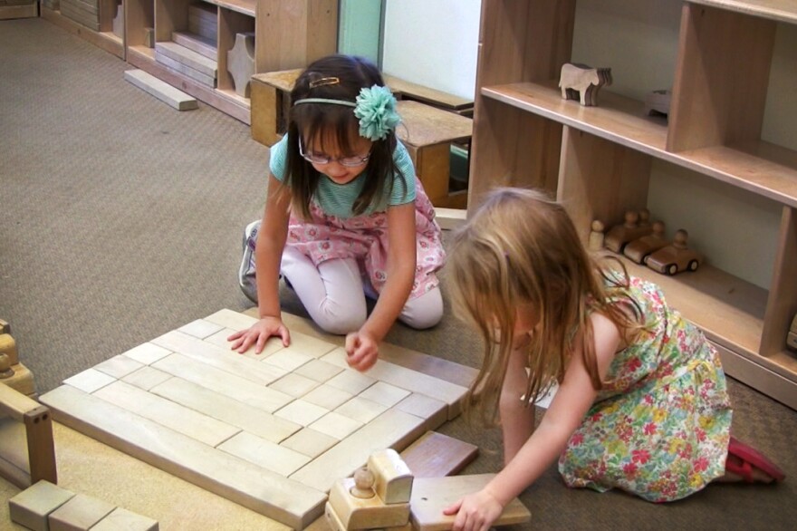 Patterns, shapes, play: Two girls work with unit blocks at Bing Nursery School.