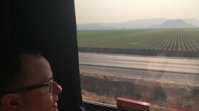 In this Dec. 16, 2017 photo, a passenger peers out the window at central California farmland as Amtrak's Coast Starlight Train makes its way from Los Angeles to Seattle.