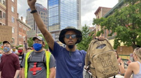 Cory Wise marches with protesters along Massachusetts Avenue on Wednesday, June 10. His bag says “this is our war on terror.