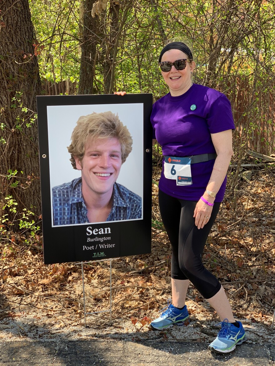 Kimberly Blake beside a photograph of Sean Blake