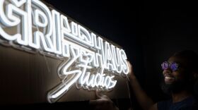 Jason Jet hangs the GrindHaus Studios sign at his new coworking recording studio in east Charlotte.