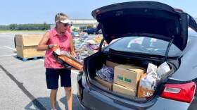 Volunteer Judy Stout helps load a trunk with food at the Food Bank of Delaware's monthly drive-thru distribution at the Crossroad Community Church in Georgetown.
