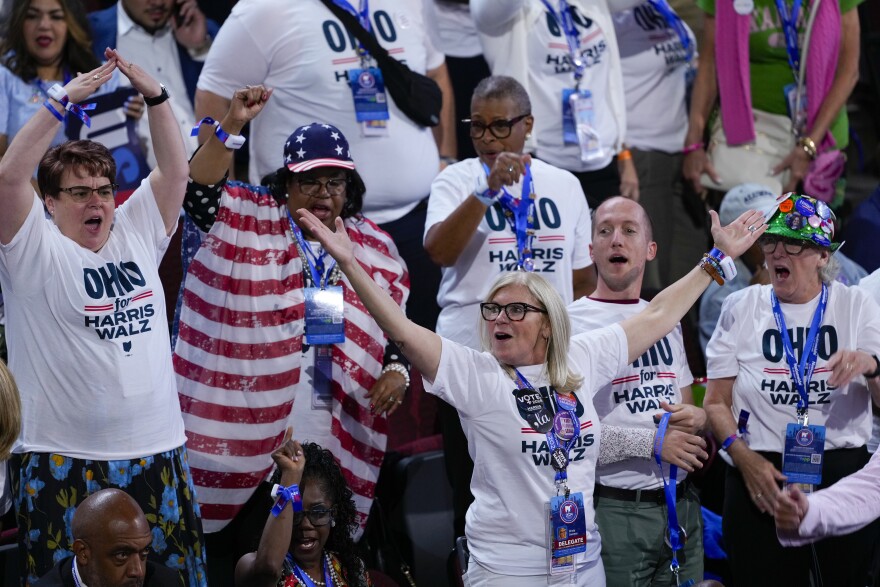 people in white shirts that say "ohio for harris walz" in blue cheer