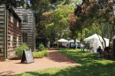 Image displaying tents of artists' work under the wooded canopy at Rehoboth Art League's wooded campus.