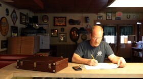 Keith Elwood, owner of Wagon Wheel Pizza in Palm Bay, Fla., fills out a worksheet for the Paycheck Protection Program, a federal small-business loan designed to help small-businesses stay open during in the wake of COVID-19.