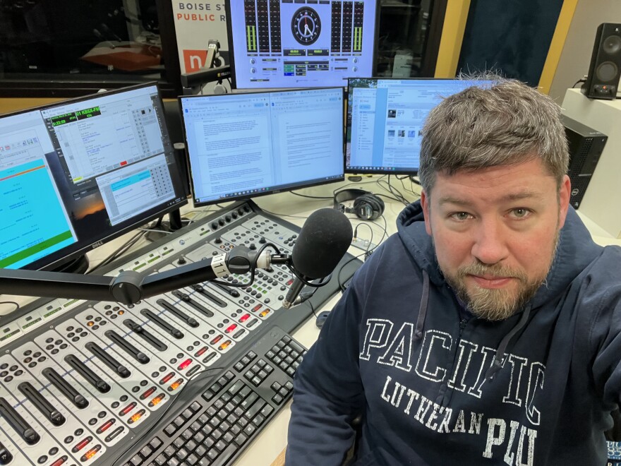Troy Oppie in front of a mixing board and computer monitors