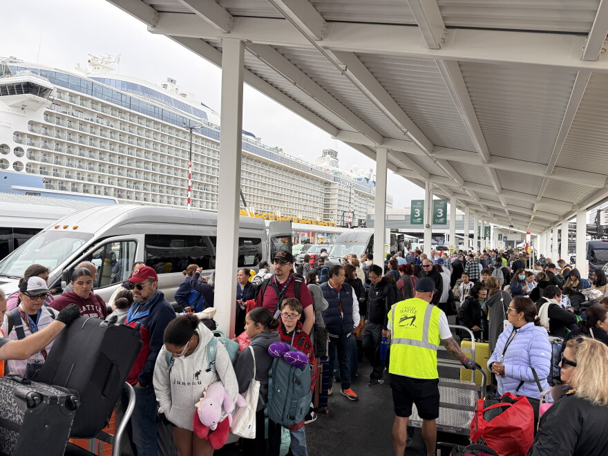 Cruise ship passengers line up at the Port of Seattle's Smith Cove Cruise Terminal, with Royal Caribbean's Anthem of the Seas in the background on Aug. 10, 2026.