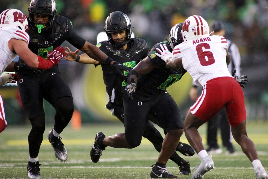 Oregon quarterback Dante Moore (5) runs the ball during the first half of an NCAA college football game against Wisconsin, Saturday, Oct. 25, 2025, in Eugene, Ore. 
