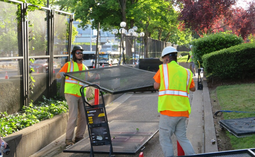 Workers stacking sections of fence. 