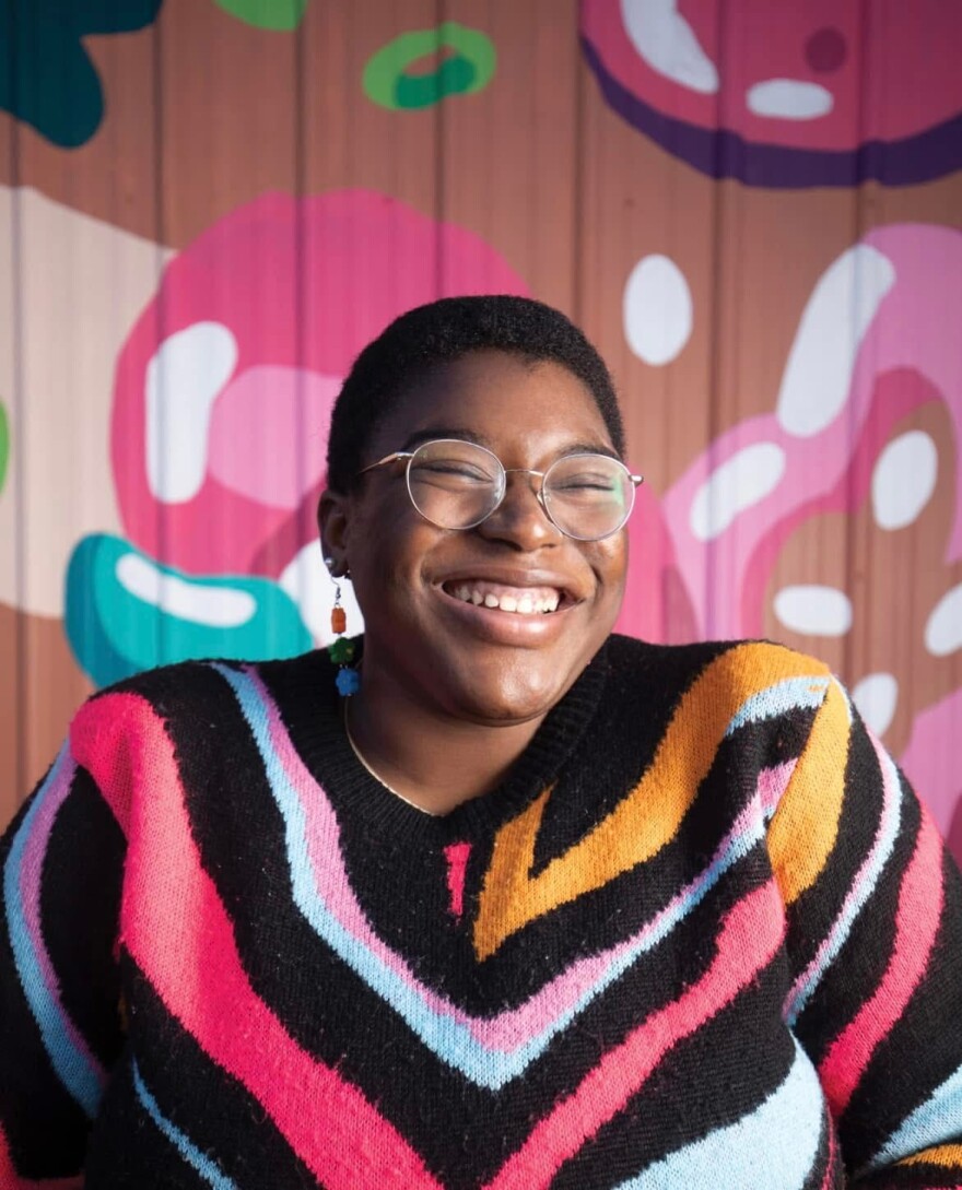 A picture of Inique Harris, a Louisiana native, illustrator, and toy designer, smiling.