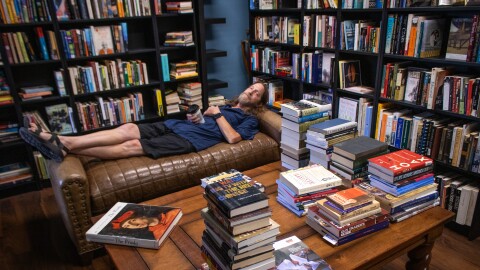 Underground Books owner D.S. Andersen demonstrates the comfort of the furniture in his Ogden shop’s reading room, July 17, 2026.