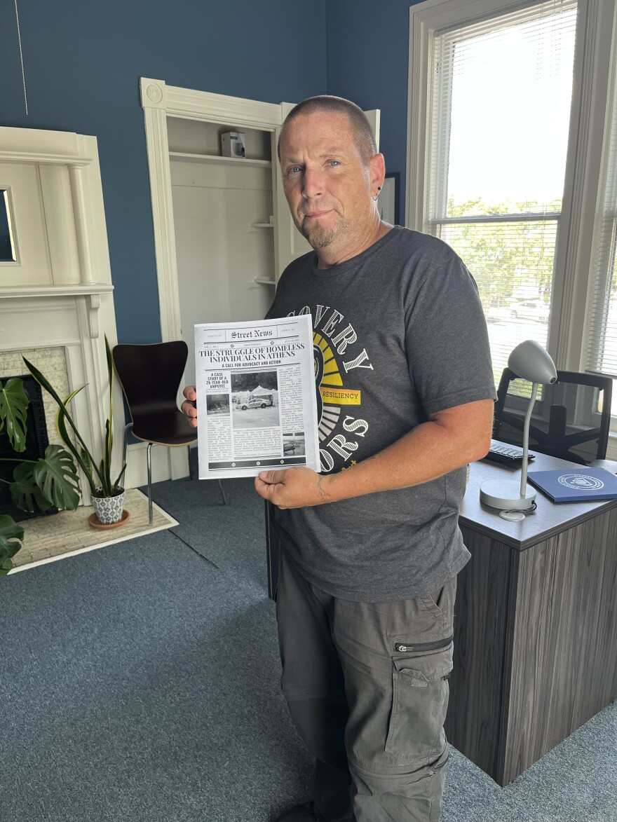 Michael Moss, Community Engagement Coordinator, with the first edition of the Athens Homeless Coalition's Street News.
