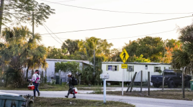 Una pareja de trabajadores agrícolas caminan a casa en Immokalee, Florida, en el 2017 después de que el huracán Irma impactó al pequeño pueblo.