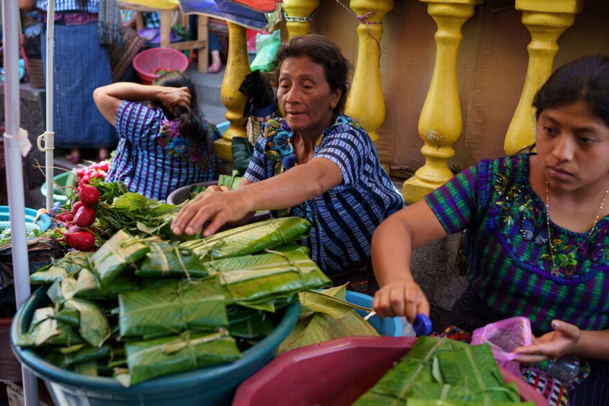 Local Tz'utujil Maya women sell Patín, a local meat and tomato stew, at the Santiago Atitlán market.