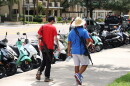 Two men who appear to be armed with rifles walk across from Tigert Hall, where protesters gathered, followed by a UFPD officer, in Gainesville Fla., Wednesday, Sept. 9, 2026. (Julianna Bendeck/WUFT News)