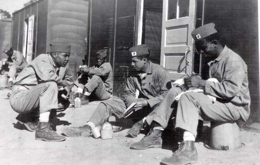 Recruits wash their eating utensils outside temporary barracks at Montford Point, N.C. during World War II.