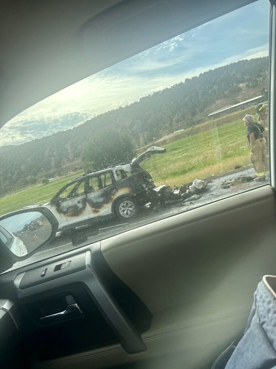 A passerby captured a photo of the fire's aftermath, including the driver's possessions piled behind the car.