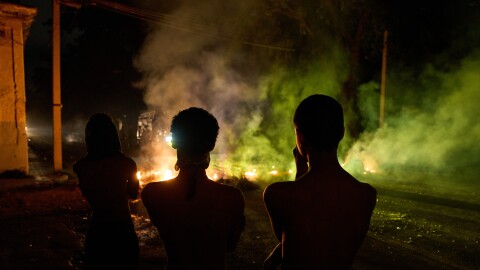 People look at a barricade set up by residents protesting 