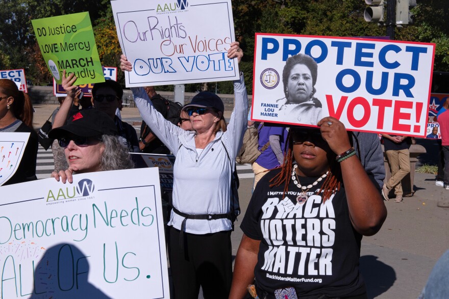 Voting rights activists gather outside the Supreme Court in Washington, early Wednesday, Oct. 15, 2025, as the justices prepare to take up a major Republican-led challenge to the Voting Rights Act, the centerpiece legislation of the Civil Rights Movement. (AP Photo/Cliff Owen)