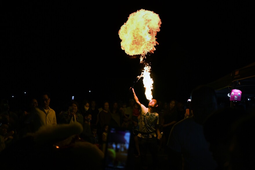 Volunteer Jinn Hoang breaths fire to lead the Lion Dance for luck that represents prosperity and goodness in every home during the Mid-Autumn Festival at Saint Andrew Dung-Lac Parish in West Hartford, Connecticut September 24, 2022.