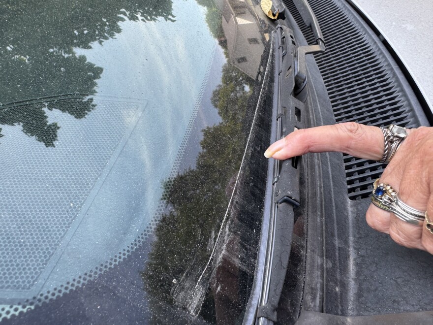 Donna Ballinger demonstrates how much fallout accumulates on her car overnight. She lives across from Cleveland-Cliffs' Middletown Works