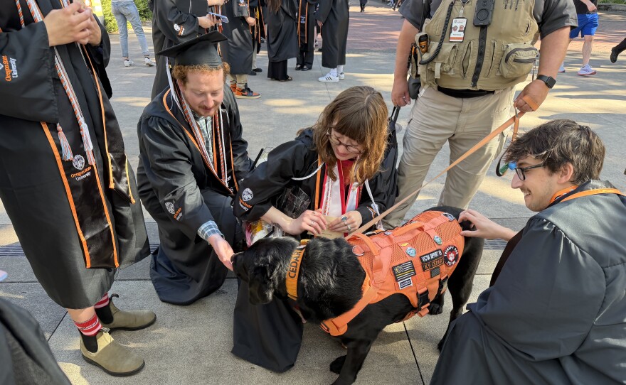 Graduates pet the Cedar the Oregon State University public safety wellness dog, June 13, 2026.