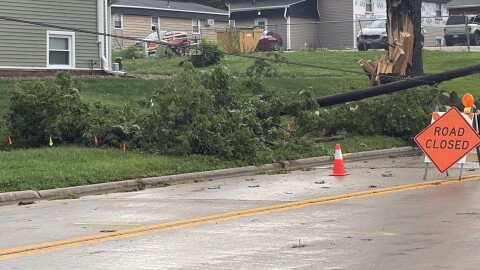 A downed power line, broken tree, and road closed sign from Aug 13 thunderstorms in Bloomington Normal.