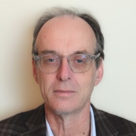 John Koehlinger wearing a blazer and glasses