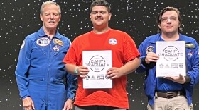 Auq-uwey O'John, (center) graduates from Space Camp in Huntsville, Alabama, alongside Robert "Hoot" Gibson, retired NASA astronaut (left).