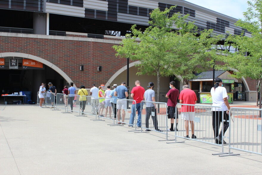 Residents wait in line outside the entrance of Rose Music Center to check-in for COVID-19 testing.