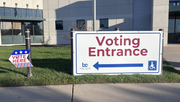 A big white sign with a red arrow and letters reads: "Voting Entrance."