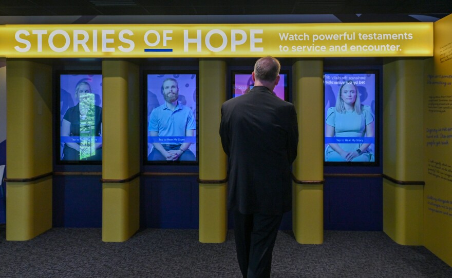 The Rev. Gerald Shantillo listens to a story from one of the displays in the People of Hope Museum, which parked outside Nay Aug Park in Scranton.
