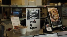A sign at Off the Bone Barbeque explains that patio dining is available, though indoor dining is closed due to the pandemic.