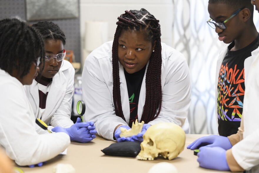 Using a plastic skull, archaeologist Alicia Odewale teaches a lesson about Tulsa's ongoing search for mass graves containing victims of the city's 1921 race massacre. She taught it at Black History Saturdays, a free private program designed for students to learn unvarnished lessons in African American history that teachers say a new law targeting race education has made harder to honestly teach.