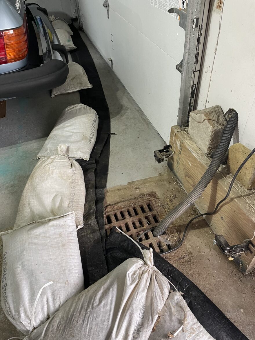 Lee Forsyth has a system for protecting his home from flooding, including this drain and sandbag system just inside the barricaded garage door. He hasn’t flooded, but his contraption may have prevented him from getting federal funds to elevate his home.