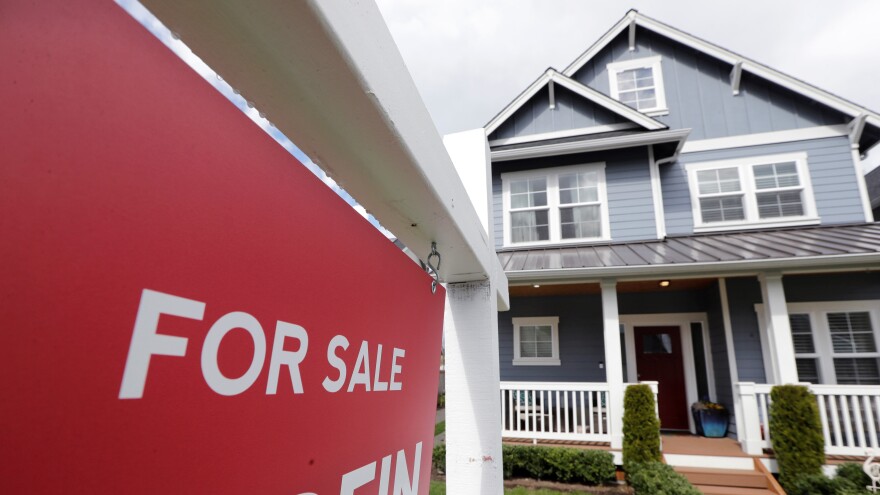 In this April 1, 2020 photo, a "For Sale" sign stands in front of a home that is in the process of being sold.