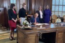 Gov. Mike Kehoe signs into law Tuesday legislation that removes legal barriers for pregnant women seeking divorce, while, from left, Rep. Ashley Aune, Sen. Jill Carter, Rep. Cecelie Williams and Rep. Raychel Proudie watch.