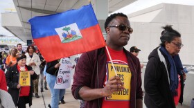 A man carries a Haitian flag during a rally 