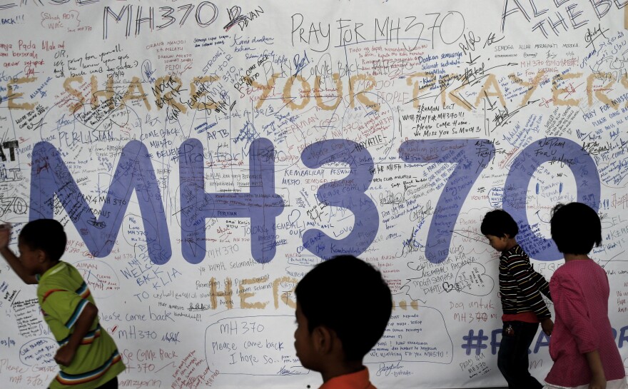 Children run past dedication messages and well wishes displayed for passengers and others involved with the missing Malaysia Airlines jetliner MH370 on the walls of the Kuala Lumpur International Airport, on March 13.
