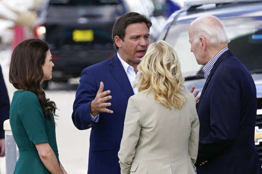 President Joe Biden and first lady Jill Biden listen to Florida Gov. Ron DeSantis speak as they arrive to tour an area impacted by Hurricane Ian on Wednesday, Oct. 5, 2022, in Fort Myers Beach, Fla. Casey DeSantis the wife of the governor listens at left. 