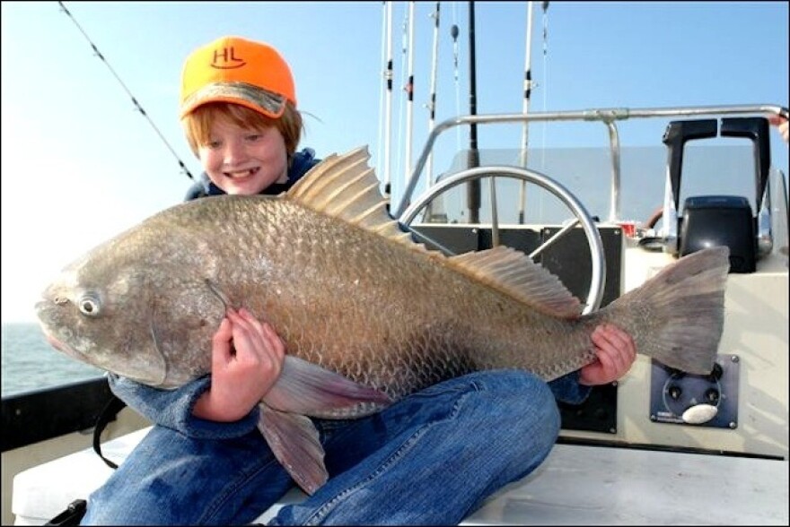 One of the fishermen and a big black drum he caught with Capt. Mike Williams' team