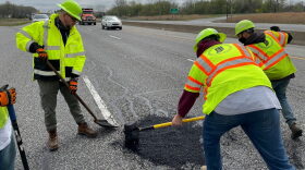 Indiana Department of Transportation workers patch a road.