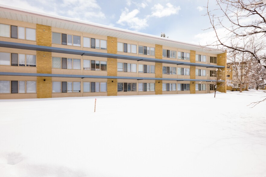 A university apartment building next to a very snowy area.