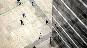 People walk by an office building at the business district of La Defense west of Paris on October 7, 2020. (Christophe ARCHAMBAULT / AFP)  