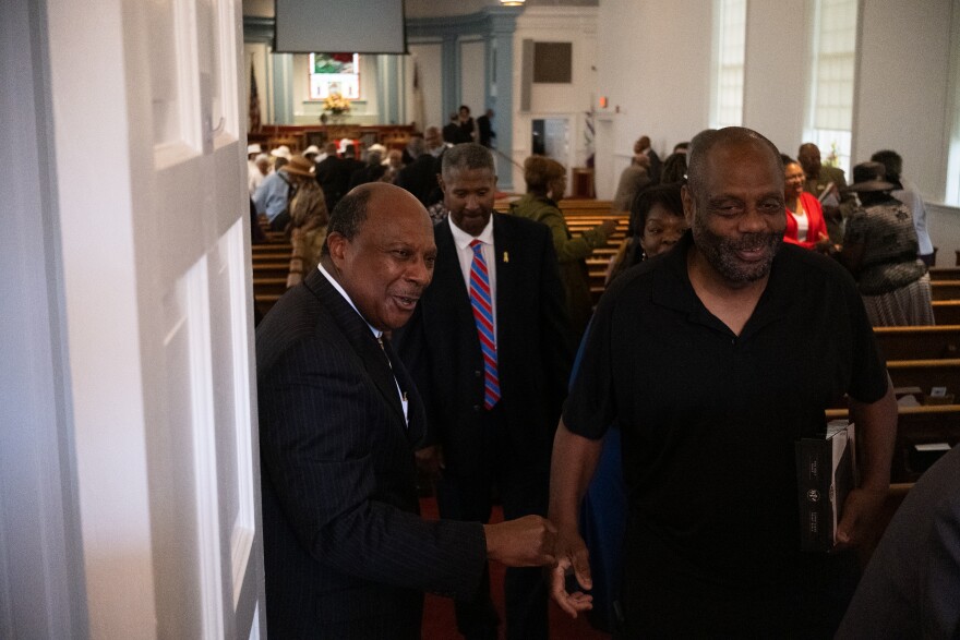 Pastor Davis meets with members and visitors at First Baptist Church as they leave following service.